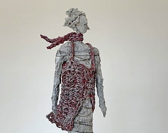 Slim sculpture made of paper mache with a red coat in the wind, human, art, unique