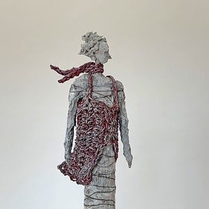 Slim sculpture made of papier-mache with red coat in the wind, human, art, unique