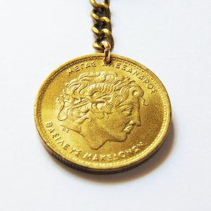 Alexander the Great Coin Keychain. 100 Drachma Brass Coin from Greece. Years issued 1992, 1994. Vergina Sun Symbol. Total length 3.5 inches