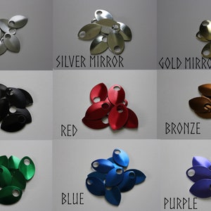 May include: Nine metal scales in various colours, including frost, silver mirror, gold mirror, black, red, bronze, green, blue, and purple. The scales are arranged in a pile, with the colours clearly visible.