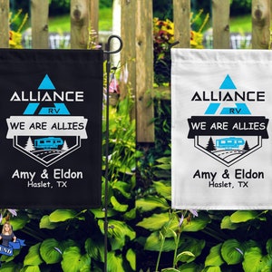 May include: Two black and white garden flags with the text "ALLIANCE RV WE ARE ALLIES" and "Amy & Eldon Haslet, TX". The flags feature a blue triangle with a white RV inside.