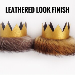 May include: Two gold crowns with black felt accents and faux fur trim. The text "LEATHERED LOOK FINISH" is displayed above the crowns.