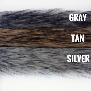 May include: Three strips of faux fur in gray, tan, and silver colors. The fur is soft and fluffy.