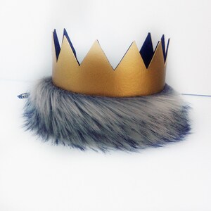May include: A gold crown with a black felt backing and a gray and white faux fur trim.