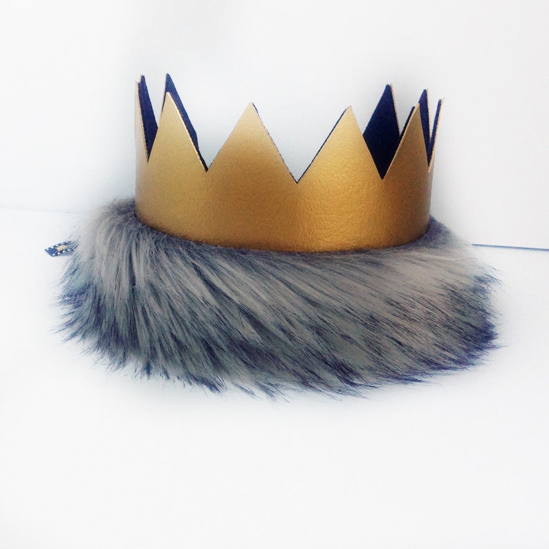May include: A gold crown with a black felt backing and a gray and white faux fur trim.