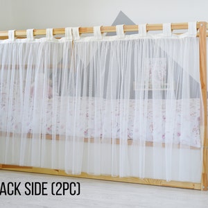 May include: White sheer curtains with a wood frame, hanging from a wooden rod. The curtains are labeled "BACK SIDE (2PC)".