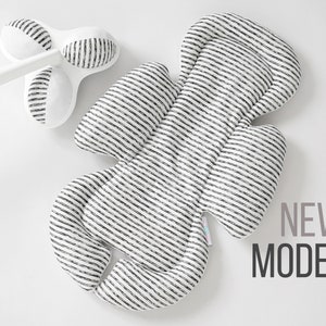 Op de afbeelding: Een babyproduct met wit en zwart gestreepte patronen, met een bijpassende witte handgreep en een drielobbige kop. De tekst "NEW MODEL" wordt in grijs en zwart weergegeven. Het product is ontworpen voor babyverzorging.