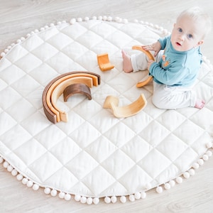 Natural baby play mat with pompom trim, Padded baby play mat, Round nursery rug