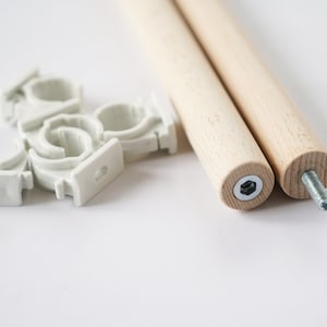 Puede incluir: Dos tacos de madera con extremos roscados y abrazaderas de tubo de pl&aacute;stico blanco. Los tacos miden aproximadamente 30 cm de largo.