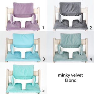 May include: Five different color high chair cushions made of minky velvet fabric. The cushions are in shades of purple, gray, light blue, turquoise, and teal. The cushions have a white tray and are designed to fit a high chair.