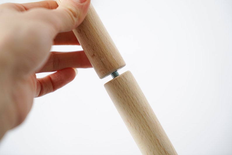 Puede incluir: Dos clavijas de madera con un tornillo de metal que las conecta. Las clavijas son de color marr&oacute;n claro y tienen un acabado liso.