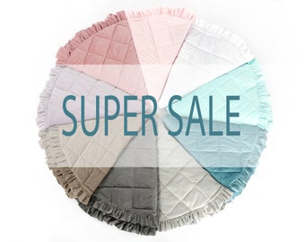 May include: A variety of round, quilted play mats with ruffled edges in different colors, including pink, light blue, gray, and beige. The mats are arranged in a circle with the text "SUPER SALE" in the center.