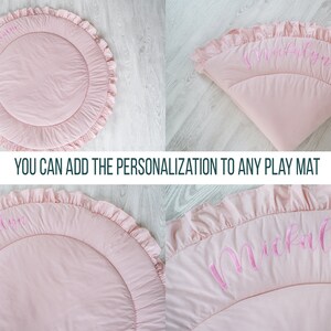 May include: A pink round play mat with a ruffled edge and the name "Mikayla" embroidered in pink on the surface. You can add the personalization to any play mat.
