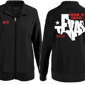 May include: Black zippered jacket with white text on the left sleeve that reads "FRONT LINER" and red text that reads "JOY". The back of the jacket has a white outline of the state of Texas with the words "COVID-19 CRISIS" and "2020-2021" in red text.