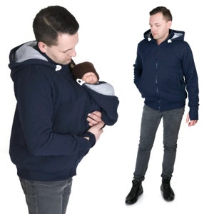 Puede incluir: Una sudadera con capucha azul marino con cierre de cremallera y un bolsillo canguro. La sudadera tiene un interior gris y una capucha con cord&oacute;n. La sudadera est&aacute; dise&ntilde;ada para llevar un beb&eacute; en el bolsillo canguro.
