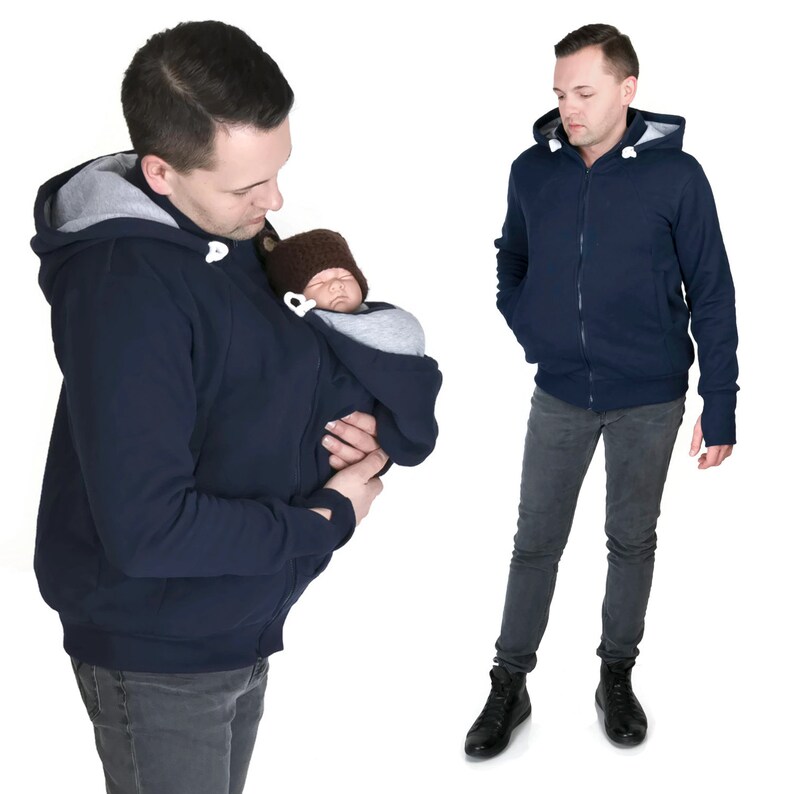 Puede incluir: Una sudadera con capucha azul marino con cierre de cremallera y un bolsillo canguro. La sudadera tiene un interior gris y una capucha con cord&oacute;n. La sudadera est&aacute; dise&ntilde;ada para llevar un beb&eacute; en el bolsillo canguro.