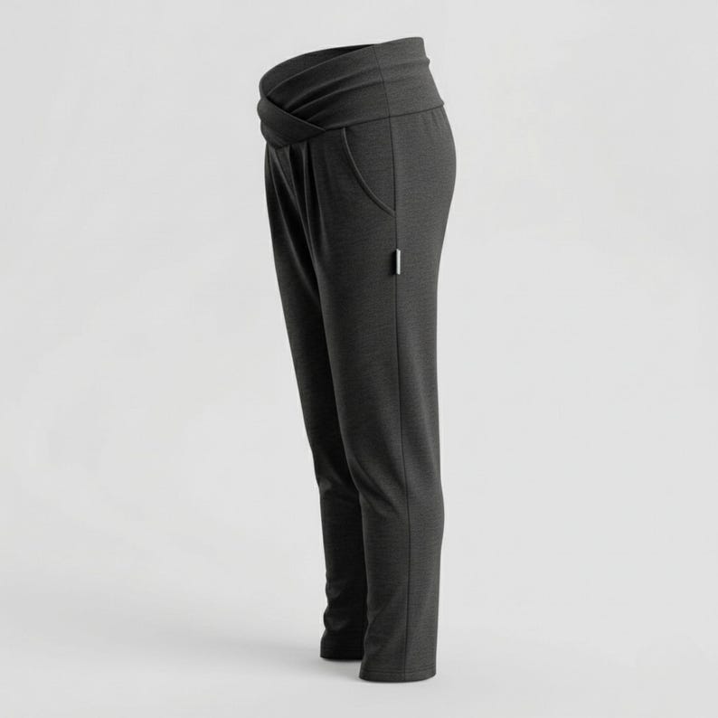 May include: Dark gray pants with a crossover waistband and pockets. The pants have a slim fit and a small white tag near the pocket. The fabric appears to be a soft, knit material. These pants are suitable for casual wear.