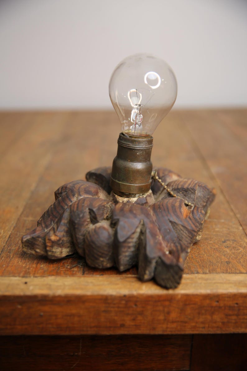 Puede incluir: Una base de l&aacute;mpara de madera vintage con un dise&ntilde;o tallado y una bombilla de vidrio transparente.