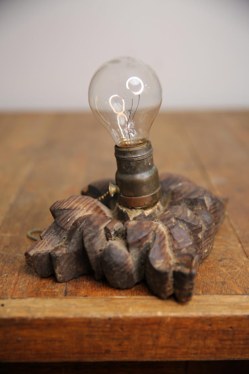 Puede incluir: Una base de l&aacute;mpara de madera vintage con un dise&ntilde;o tallado y una bombilla de vidrio transparente.