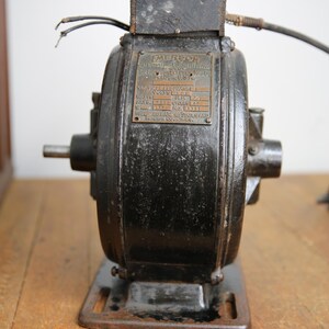 May include: A black Emerson electric motor with a brass nameplate. The nameplate reads "Emerson Electric Manufacturing Co. St. Louis, U.S.A.". The nameplate also lists the motor's specifications: Class:  SP, Phase: 1, Volts: 115, Watts: 1/3 HP, Amps: 2.7, Speed: 1725 RPM, No: 4311,  Emerson Electric Manufacturing Co. St. Louis, U.S.A.
