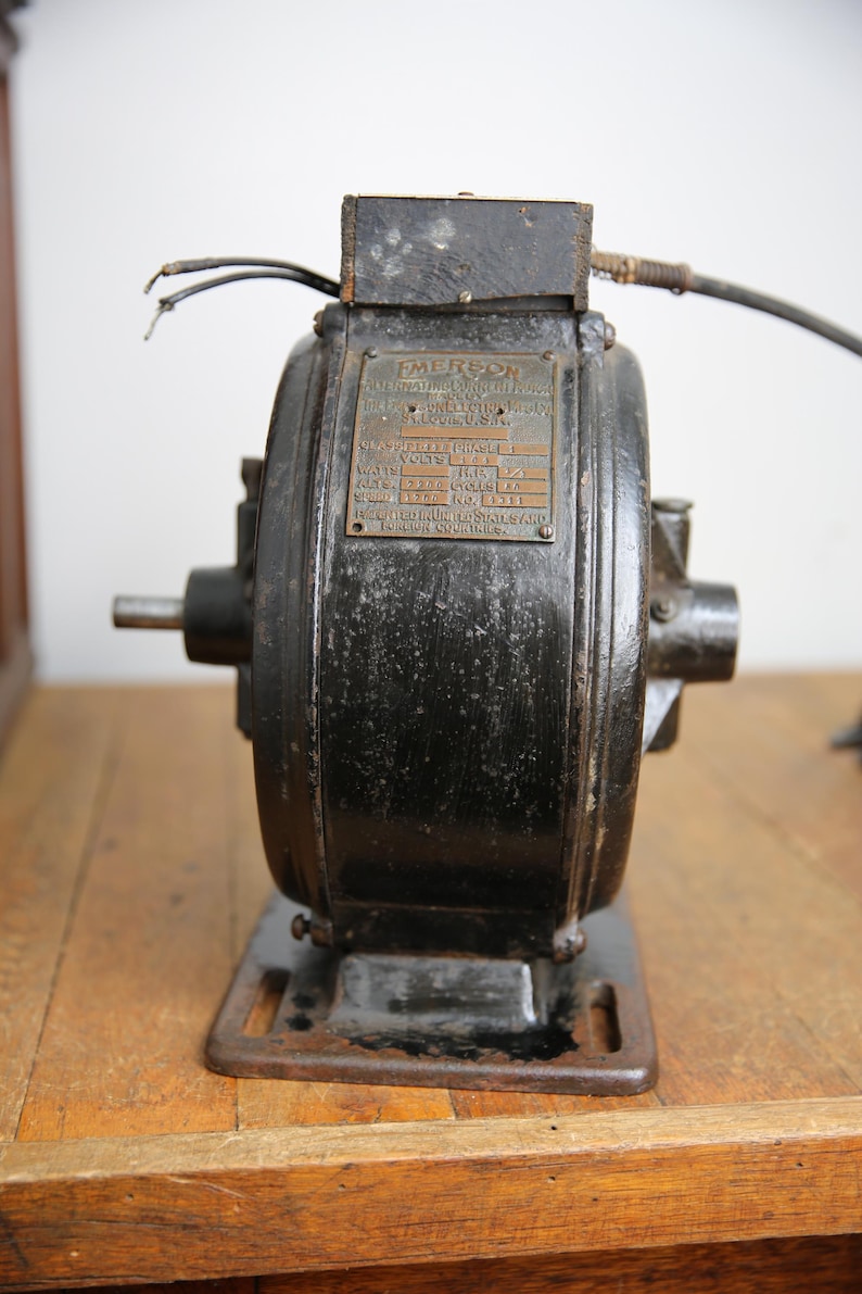 May include: A black Emerson electric motor with a brass nameplate. The nameplate reads "Emerson Electric Manufacturing Co. St. Louis, U.S.A.". The nameplate also lists the motor's specifications: Class:  SP, Phase: 1, Volts: 115, Watts: 1/3 HP, Amps: 2.7, Speed: 1725 RPM, No: 4311,  Emerson Electric Manufacturing Co. St. Louis, U.S.A.
