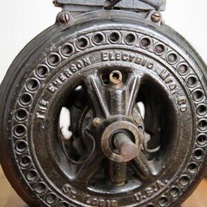 May include: Close-up of a black cast iron electric motor with the text "The Emerson Electric Mfg. Co. St. Louis, U.S.A." on the front.