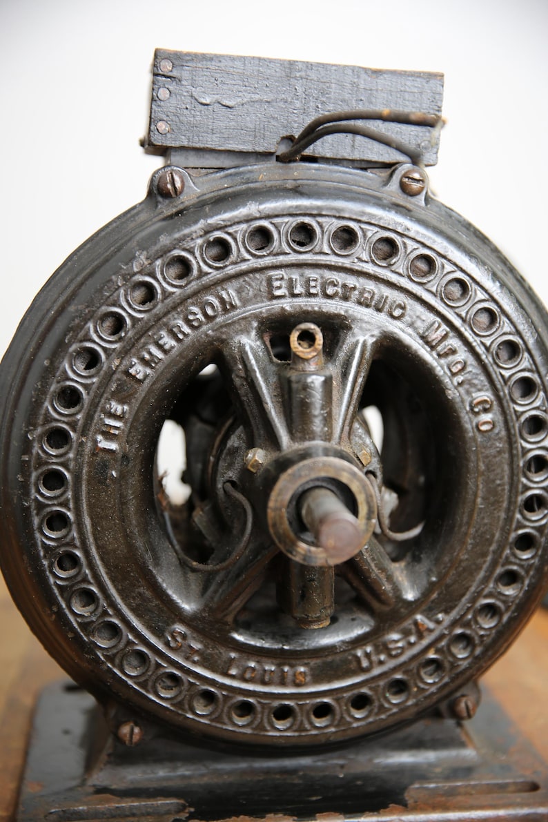 May include: Close-up of a black cast iron electric motor with the text "The Emerson Electric Mfg. Co. St. Louis, U.S.A." on the front.