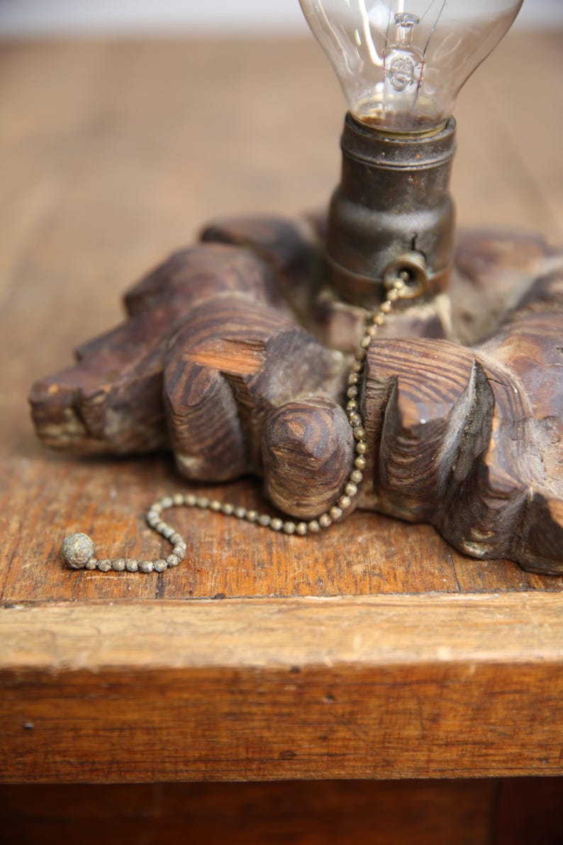 Puede incluir: Una base de l&aacute;mpara de madera con un interruptor de cadena. La base est&aacute; tallada con un dise&ntilde;o floral y tiene un acabado marr&oacute;n oscuro.