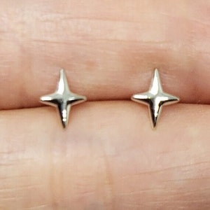May include: A pair of silver star-shaped stud earrings.