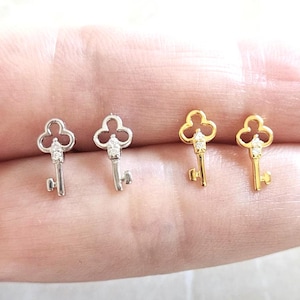 Puede incluir: Cuatro pendientes con forma de llave. Dos son de color plateado y dos de color dorado. Cada llave tiene una peque&ntilde;a gema transparente en la parte superior. Los pendientes son peque&ntilde;os y delicados.
