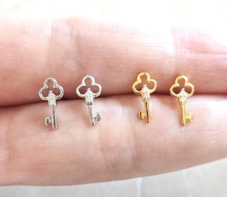 Puede incluir: Cuatro pendientes con forma de llave. Dos son de color plateado y dos de color dorado. Cada llave tiene una peque&ntilde;a gema transparente en la parte superior. Los pendientes son peque&ntilde;os y delicados.