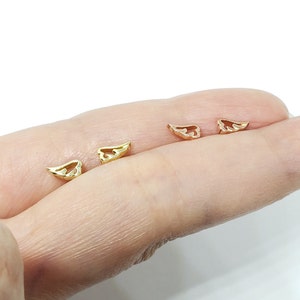 May include: Three pairs of gold and rose gold angel wing earrings. The earrings are small and delicate, and they are perfect for adding a touch of elegance to any outfit.