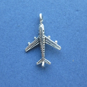 May include: Silver airplane charm pendant. The charm is detailed with a textured surface and a small loop at the top for attaching to a necklace or bracelet.