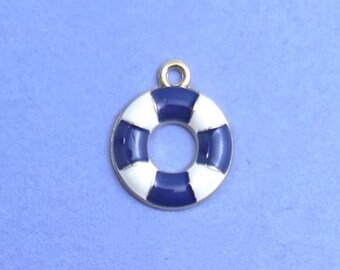 Könnte beinhalten: Ein nautischer Anhänger in Form eines Rettungsrings. Der Anhänger ist rund mit abwechselnden Abschnitten aus weißem und marineblauem Emaille. Er hat eine goldfarbene Schlaufe oben zum Befestigen. Der Anhänger befindet sich auf blauem Hintergrund.