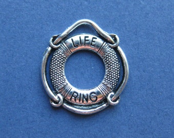 May include: A silver-colored life ring charm with the words "LIFE RING" engraved on it. The charm has a detailed, textured design and is set against a dark blue background. The charm is a nautical-themed accessory.