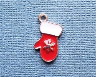 May include: A small, red and white enamel mitten charm with a gold-colored outline and a snowflake design. The charm has a loop at the top for attaching to a necklace or bracelet. The mitten is approximately 0.75 inches long.