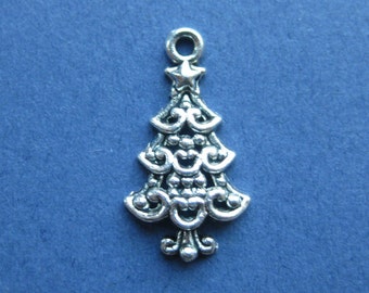 May include: A silver-colored Christmas tree charm with intricate filigree detailing. The charm features a star at the top and a loop for attaching to a necklace or bracelet. The tree design is ornate and detailed, perfect for holiday-themed jewelry.