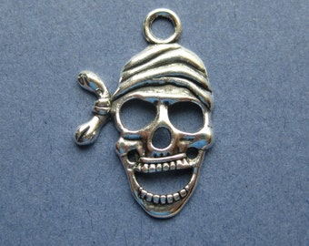 May include: Silver charm in the shape of a skull wearing an eye patch. The skull has a toothy grin and is detailed with eye sockets and a nose.