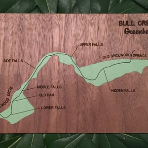 May include: A wooden map of the Bull Creek Greenbelt trail, showing the location of the Upper Falls, Side Falls, Middle Falls, Lower Falls, Hidden Falls, Old Dam, and Old Spicewood Springs Road.