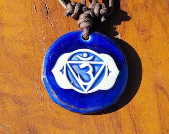 Ajna Chakra (Stirnchakra / Drittes Auge) glasurgebrannter Keramikanhänger mit verstellbaren Baumwollband