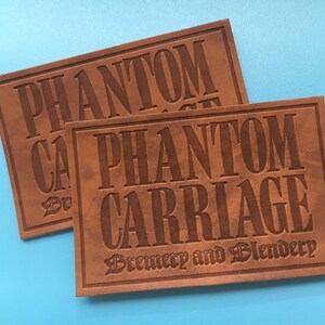 May include: Two brown leather patches with the text "Phantom Carriage Brewery and Blendersy" embossed in black.