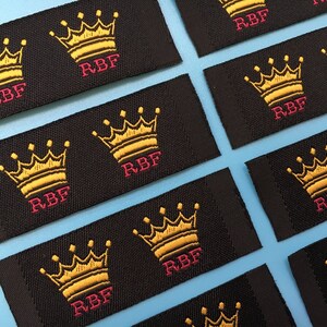 May include: Black fabric labels with a gold embroidered crown and the text "RBF" in pink.