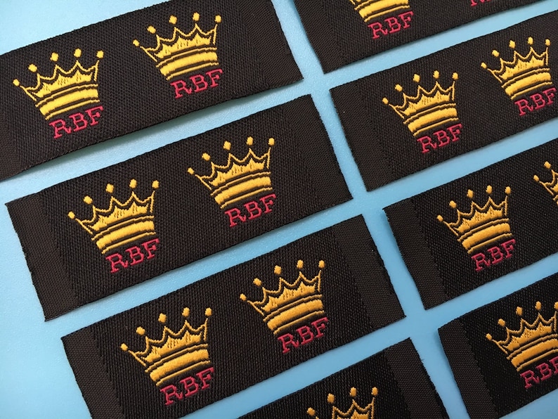 May include: Black fabric labels with a gold embroidered crown and the text "RBF" in pink.