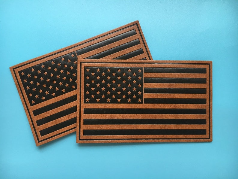 May include: Two brown leather patches with the American flag design. The flag is black and brown with white stars.
