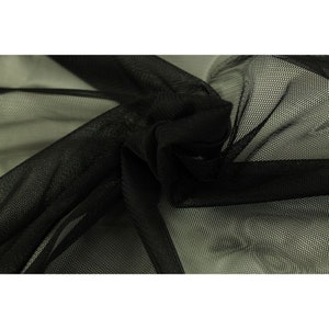 Könnte beinhalten: Schwarzer, durchsichtiger Netzstoff mit einer feinen, gleichmäßigen Webart. Der Stoff ist weich und fällt schön.