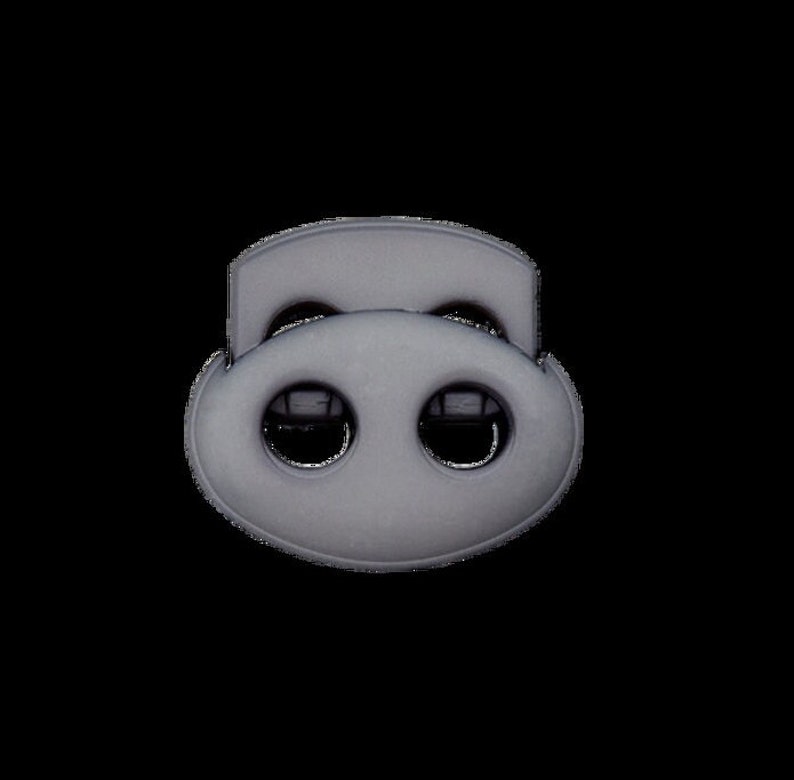 Puede incluir: Una hebilla de pl&aacute;stico negra con dos agujeros para asegurar correas o cordones.