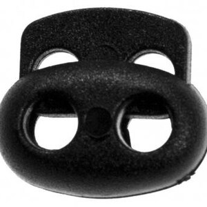 Puede incluir: Toggle de pl&aacute;stico negro con tres agujeros, utilizado para asegurar cordones o correas.