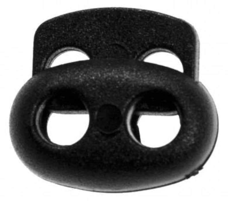 Puede incluir: Toggle de pl&aacute;stico negro con tres agujeros, utilizado para asegurar cordones o correas.