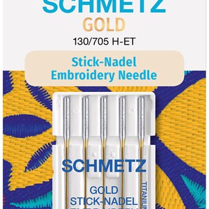 Könnte beinhalten: Eine Packung mit vier goldenen Sticknadeln von SCHMETZ. Die Nadeln befinden sich in einem weißen Kunststoffgehäuse mit dem Text "SCHMETZ GOLD STICK-NADEL EMBROIDERY 130/705 H-ET 75/11 TITANIUM NITRIDE".