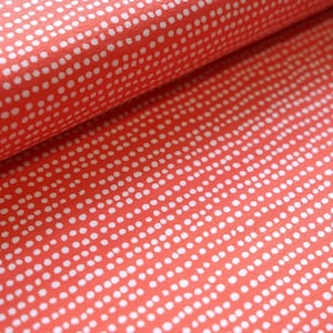 Könnte beinhalten: Korallenroter Stoff mit weißem Punkte-Muster. Die Punkte sind in horizontalen Reihen angeordnet.